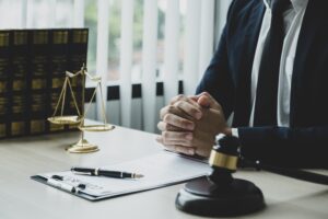 A personal injury solicitor sat at a desk with a set of scales and a gavel.